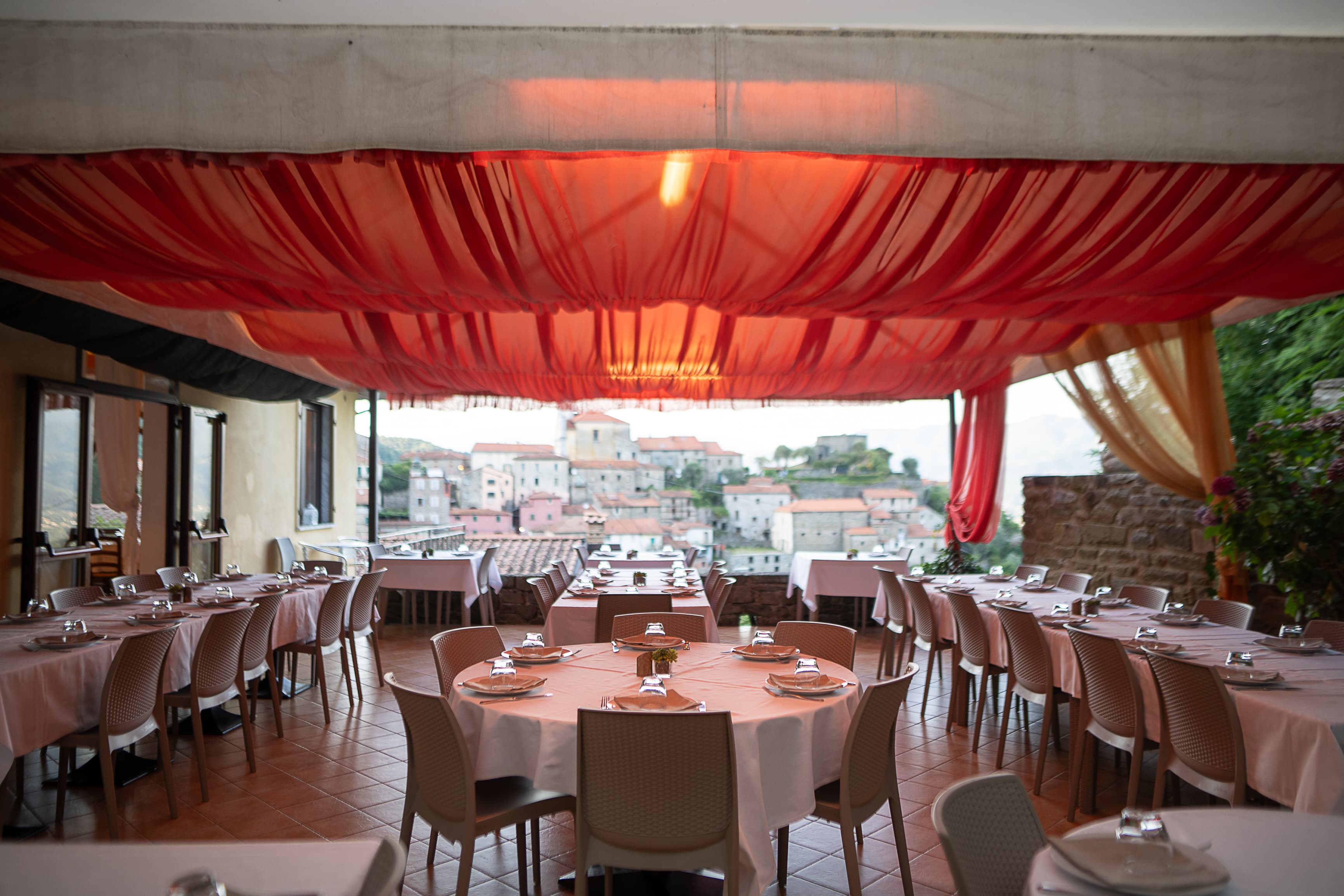 La terrazza di El Caracol apparecchiata con vista sul borgo medievale di Mulazzo
